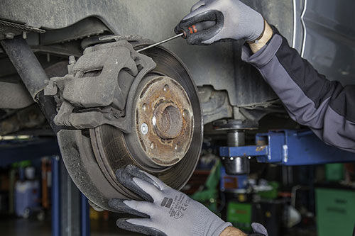 Technician inspecting a brake disc during a vehicle service